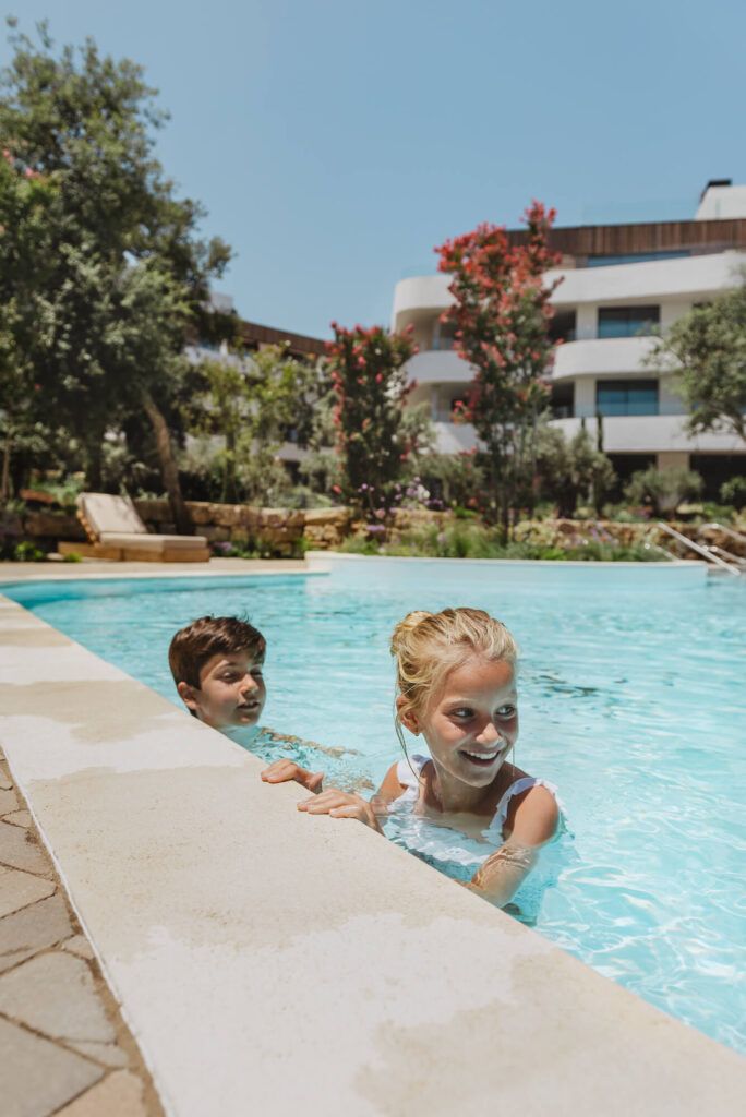 alt="Fotografía de lifestyle en la piscina de Village Verde por By Nau"