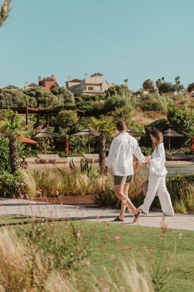 alt:"Fotografía profesional de una pareja de mujer y hombre paseando. Fotografía realizada por By Nau en The Beach, Sotogrande".